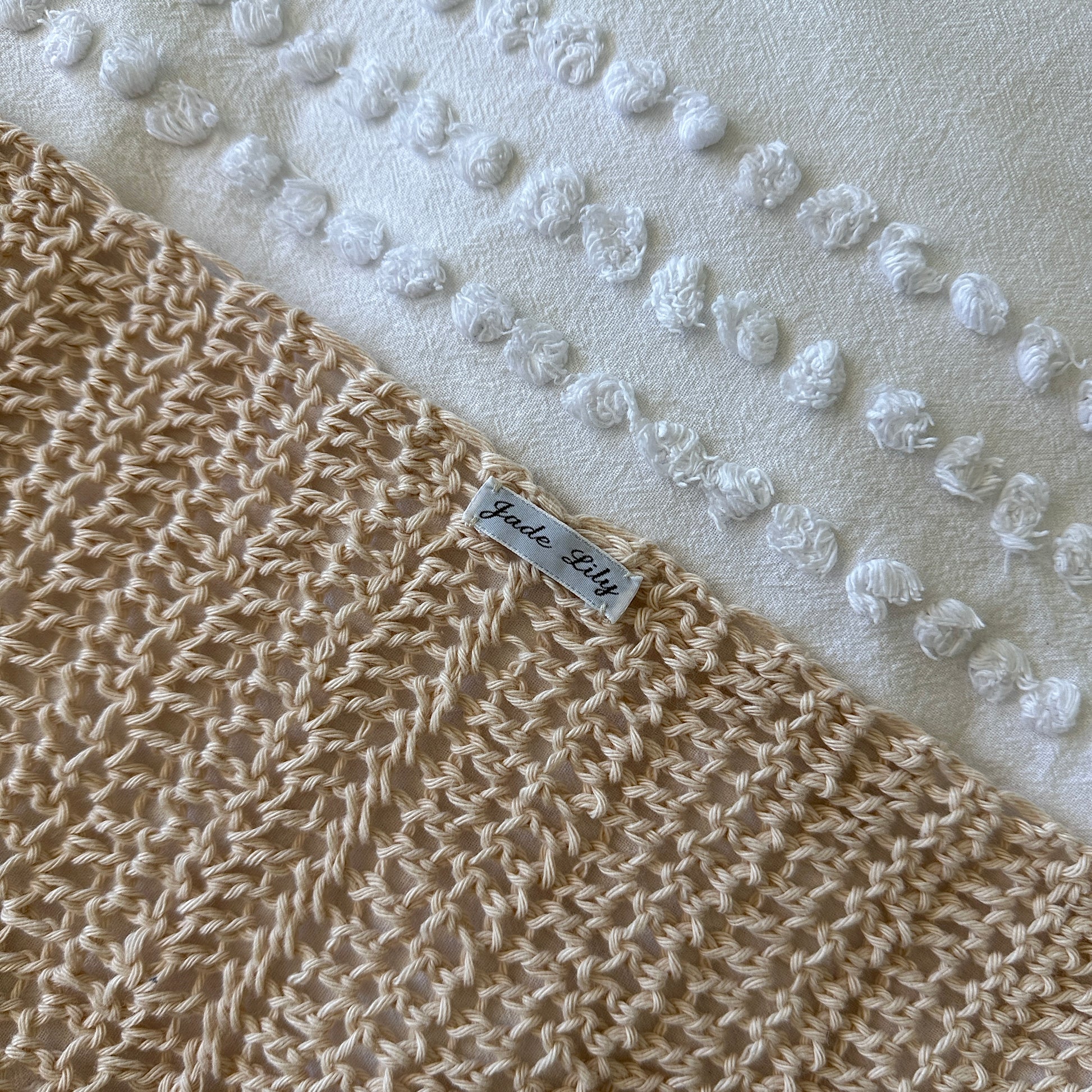 Crochet poncho with a label on a textured white background