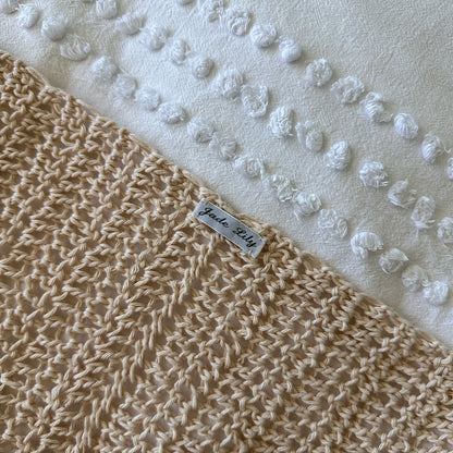 Crochet poncho with a label on a textured white background